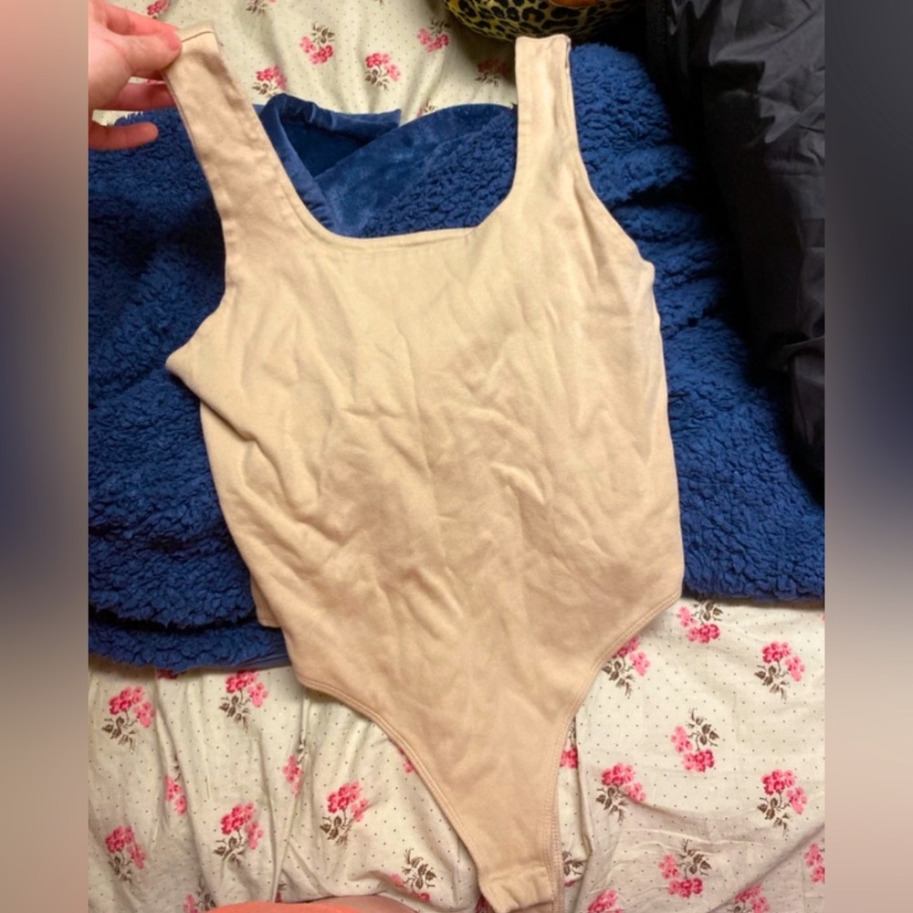 A creamy color, bodysuit tank top that buttons underneath by the Lady area !!